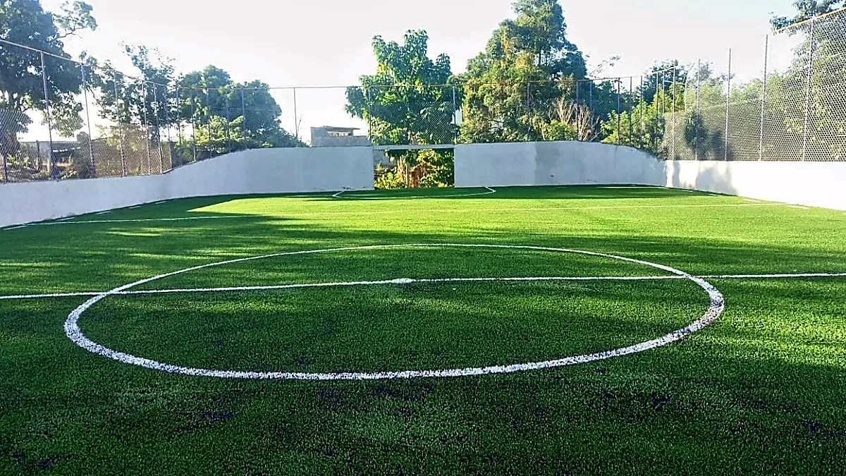 Cancha de fútbol rápido con pasto sintético en Escuela Secundaria General José A. Baños Aguirre, Santiago Pinotepa Nacional, Oaxaca: líneas de juego insertadas en el pasto