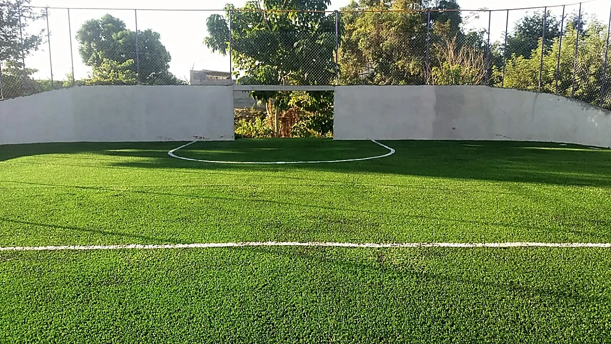 Cancha de fútbol rápido con pasto sintético en Escuela Secundaria General José A. Baños Aguirre, Santiago Pinotepa Nacional, Oaxaca: la cancha desde la línea lateral