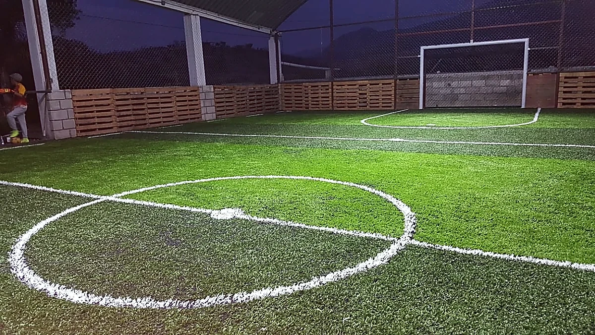Cancha de fútbol rápido con pasto sintético en Huajolotitlán, Oaxaca: líneas de juego insertadas en el pasto