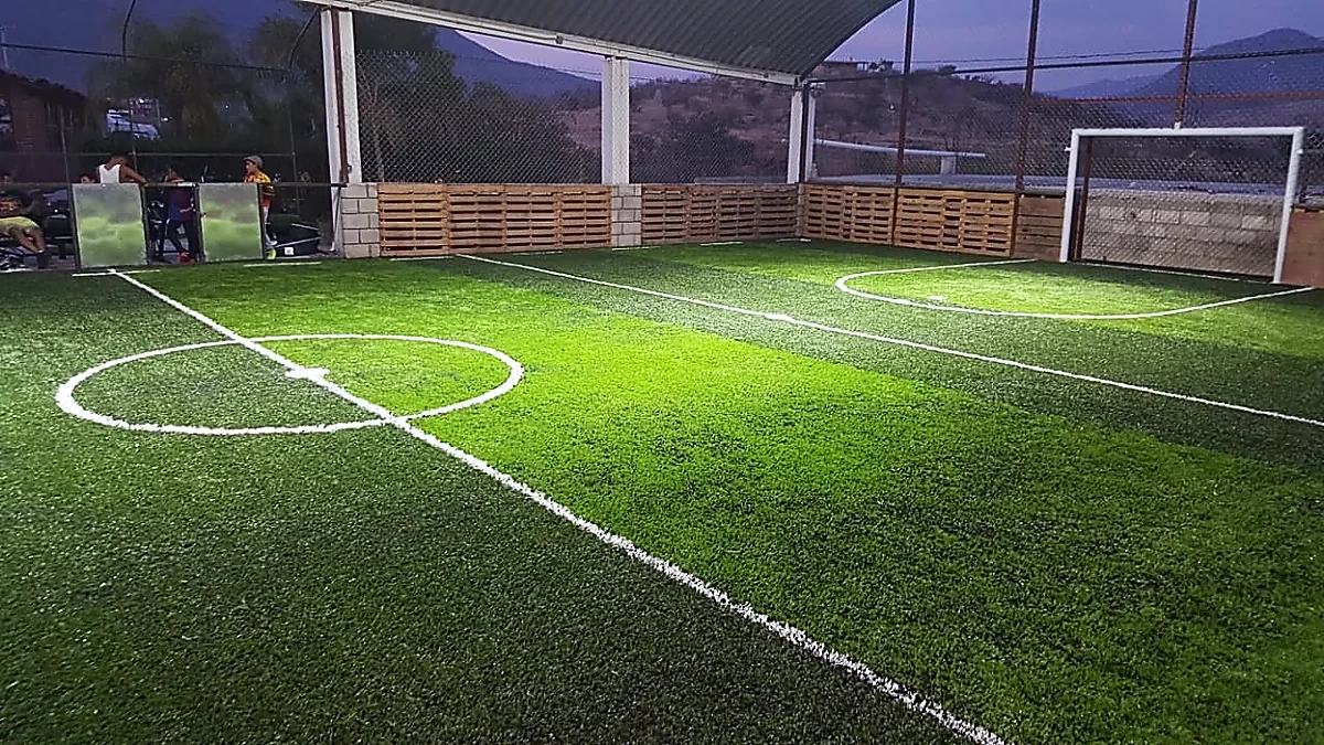 Cancha de fútbol rápido con pasto sintético en Huajolotitlán, Oaxaca: pasto sintético deportivo recién cepillado