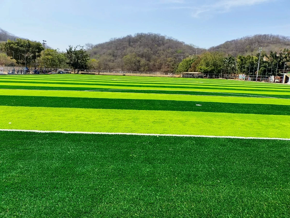 Cancha de fútbol soccer con pasto sintético en Unidad Deportiva la Crucecita, La Crucecita (Huatulco), Oaxaca: la cancha desde la línea lateral