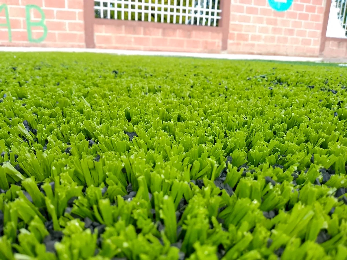 Detalle del pasto sintético de la cancha de fútbol 5 en San Juan Tetla, Puebla