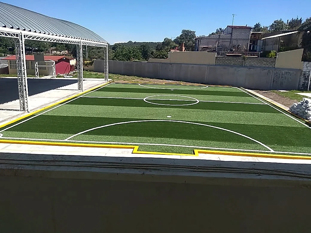 Detalle del pasto sintético de la cancha de fútbol 5 en San Nicolás de los Ranchos, Puebla