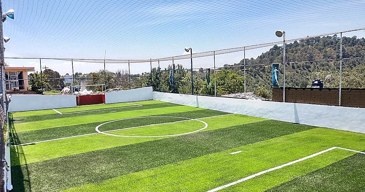 Cancha de fútbol 7 con pasto sintético en Santa Rita Tlahuapan, Puebla: la cancha desde la línea lateral