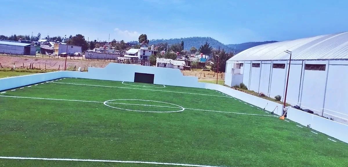 Cancha de fútbol rápido con pasto sintético en Aztequilla, Puebla: la cancha desde la línea lateral
