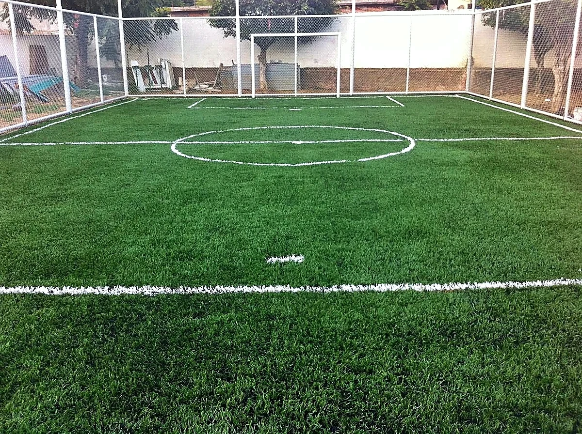 Cancha de fútbol 7 con pasto sintético en Escuela Primaria Mariano Escobedo, Jalpan de Serra, Querétaro: líneas de juego insertadas en el mismo pasto