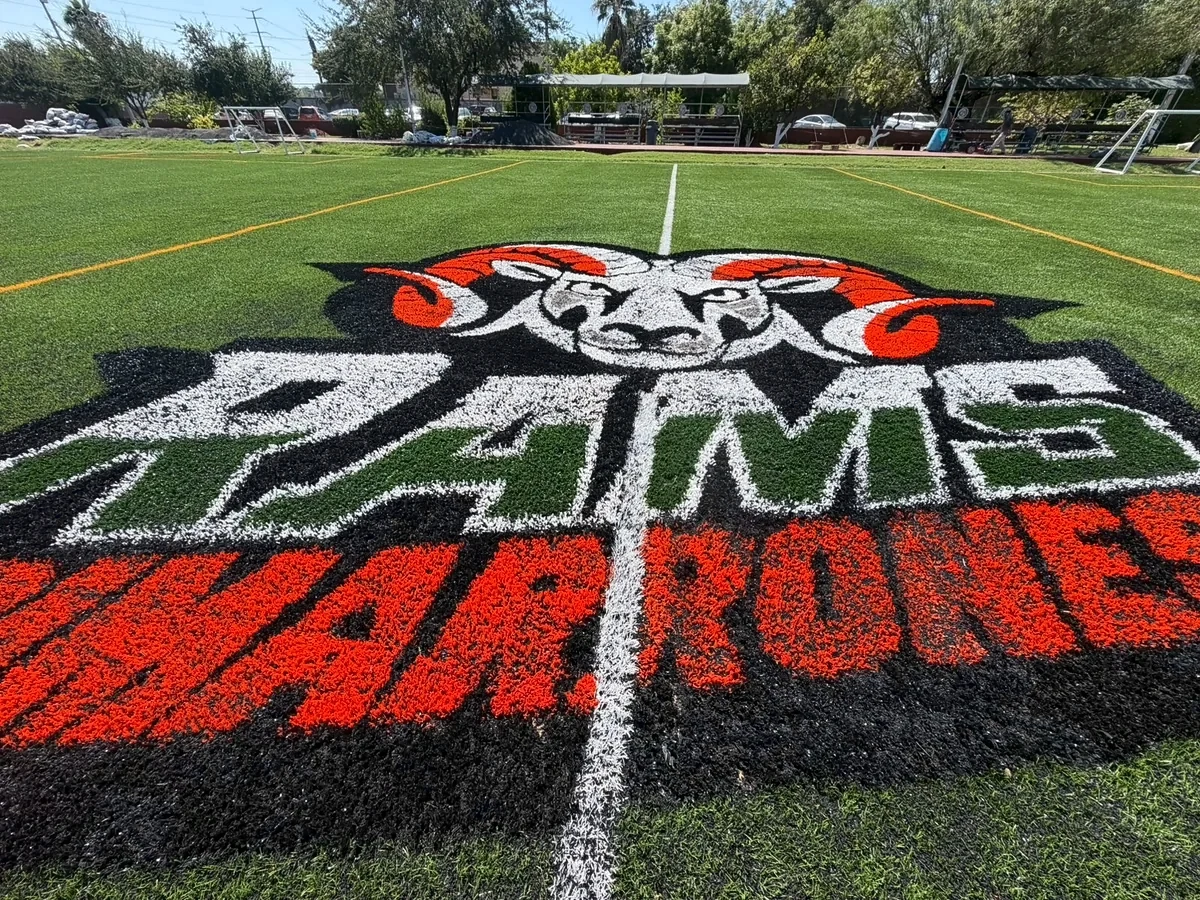Escudo del colegio insertado en el pasto sintético de la cancha del Colegio Mexicano, Reynosa