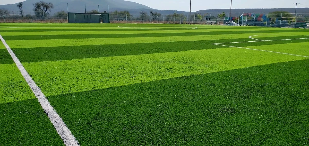 Cancha de fútbol 7 con pasto sintético en Unidad Deportiva de Rayón, San Luis Potosí: la cancha desde la línea lateral