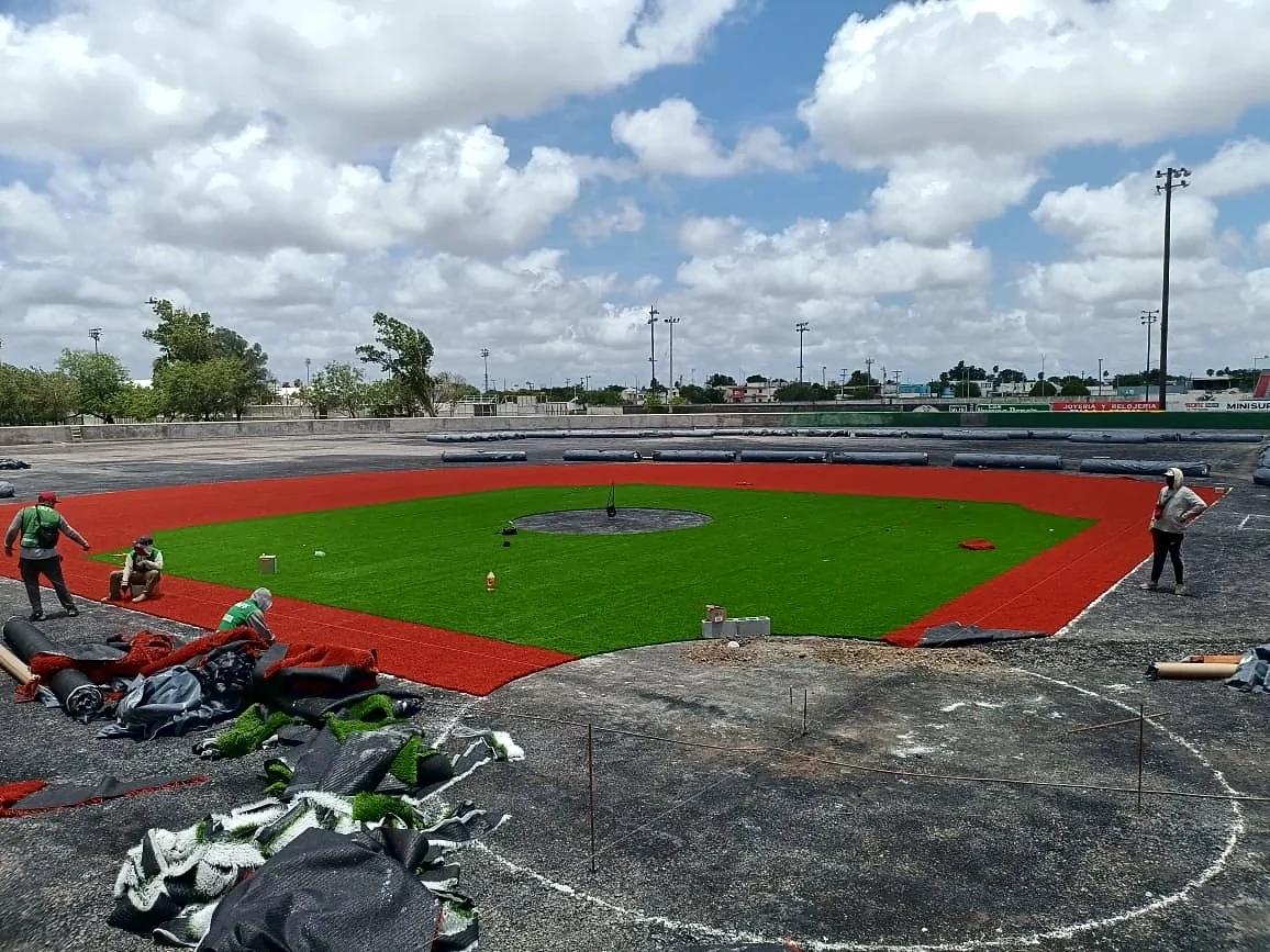 Instalación del pasto sintético del campo de béisbol en Matamoros: rollos extendidos sobre la base del jardín