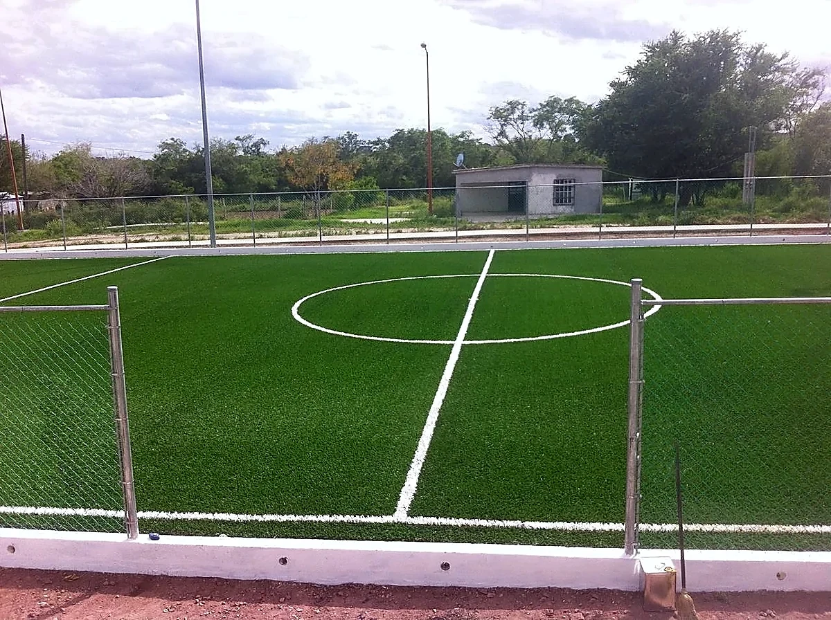Cancha de fútbol 7 con pasto sintético en Unidad Deportiva el Tamul de la Rivereña, San Fernando, Tamaulipas: la cancha desde la línea lateral
