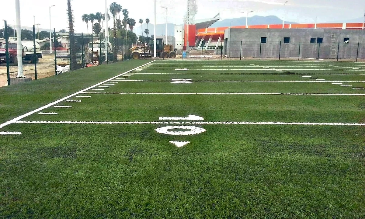 Yarda 10 y hash marks insertados en el pasto sintético de la cancha de tochito en Ciudad Victoria, Tamaulipas
