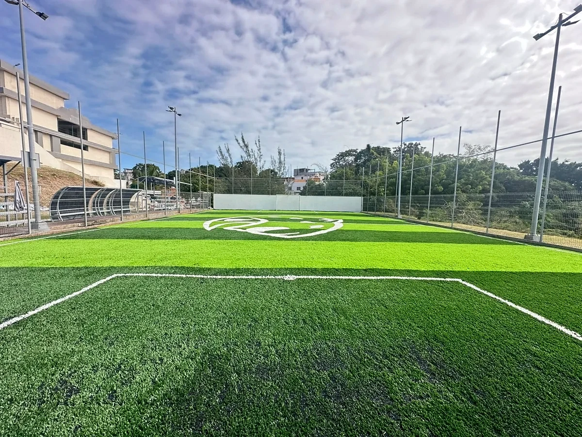 Cancha de fútbol 7 de la UNE en Tampico vista desde la línea de fondo con el logotipo al centro