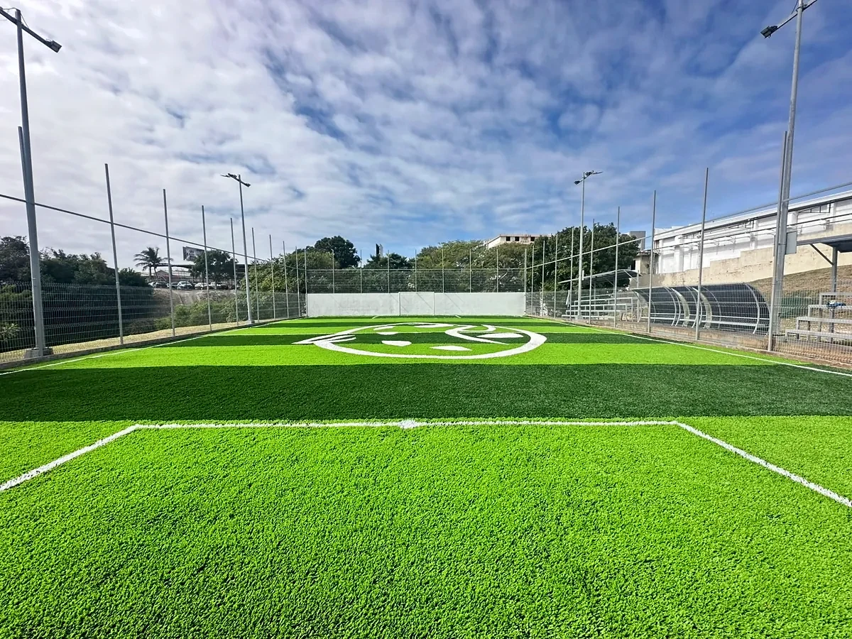 Cancha de fútbol 7 con pasto sintético a franjas y logotipo integrado en la UNE, Tampico