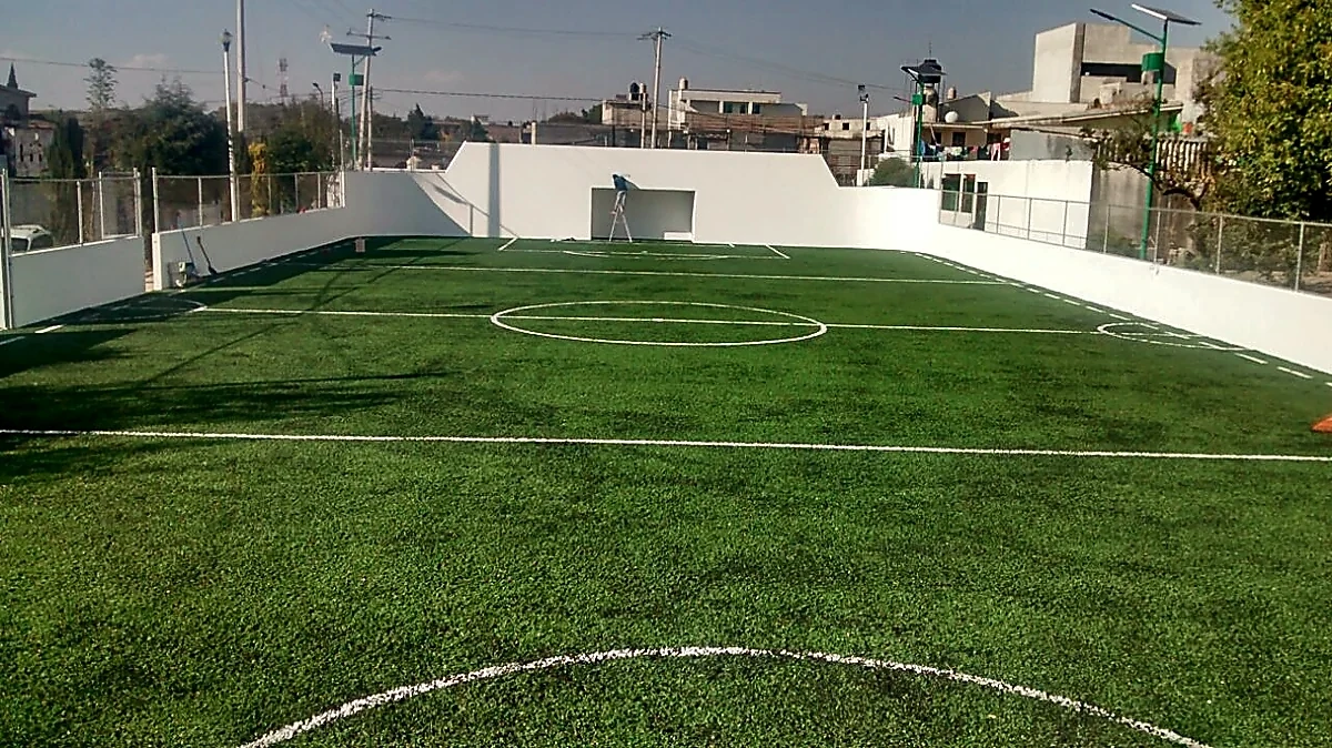 Cancha de fútbol 7 con pasto sintético en Campo Deportivo Papalota, Papalotla, Tlaxcala: la cancha desde la línea lateral