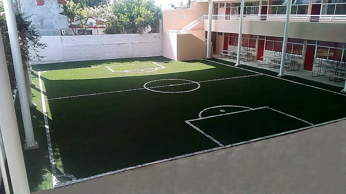 Cancha de fútbol 5 con pasto sintético en Colegio Americano, Poza Rica, Veracruz: la cancha desde la línea lateral