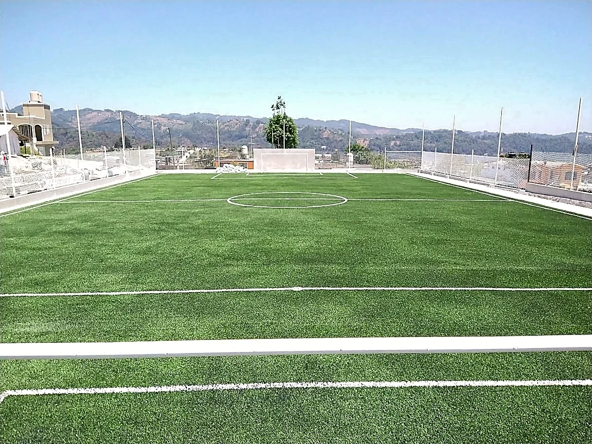 Cancha de fútbol 5 con pasto sintético en Unidad Deportiva Apatlahuac, Veracruz: la cancha desde la línea lateral