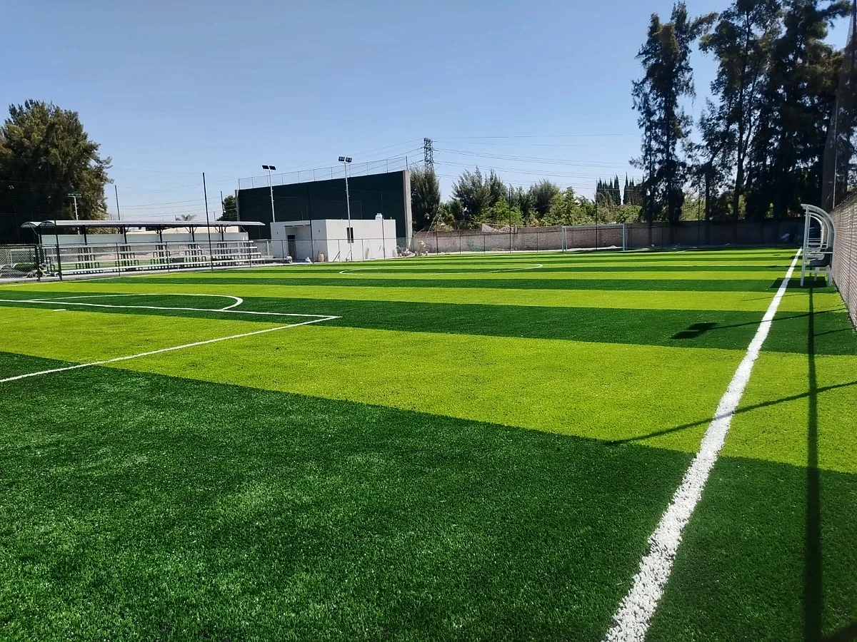 Cancha de fútbol 7 con pasto sintético y bancas techadas en el Club Atlético Balam, Zapopan, Jalisco
